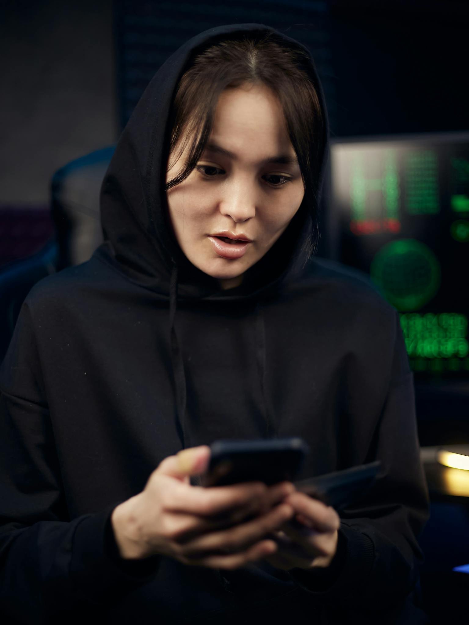 Woman in Black Hoodie Holding Black Smartphone